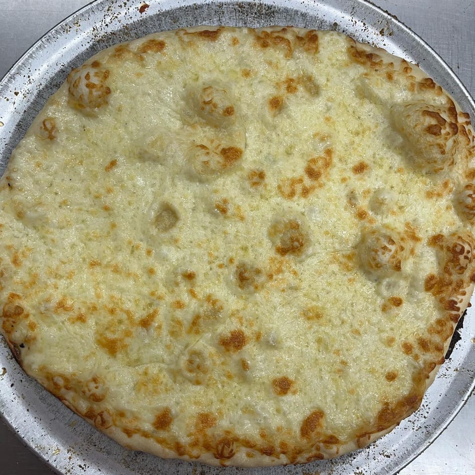 Jake's Pizza Rostraver's cheese pizza, golden brown and bubbly, on a metal pizza pan.